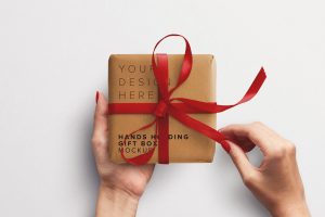 Hands Holding Gift Box with Ribbon