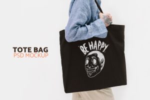 Woman holding a black tote bag mockup